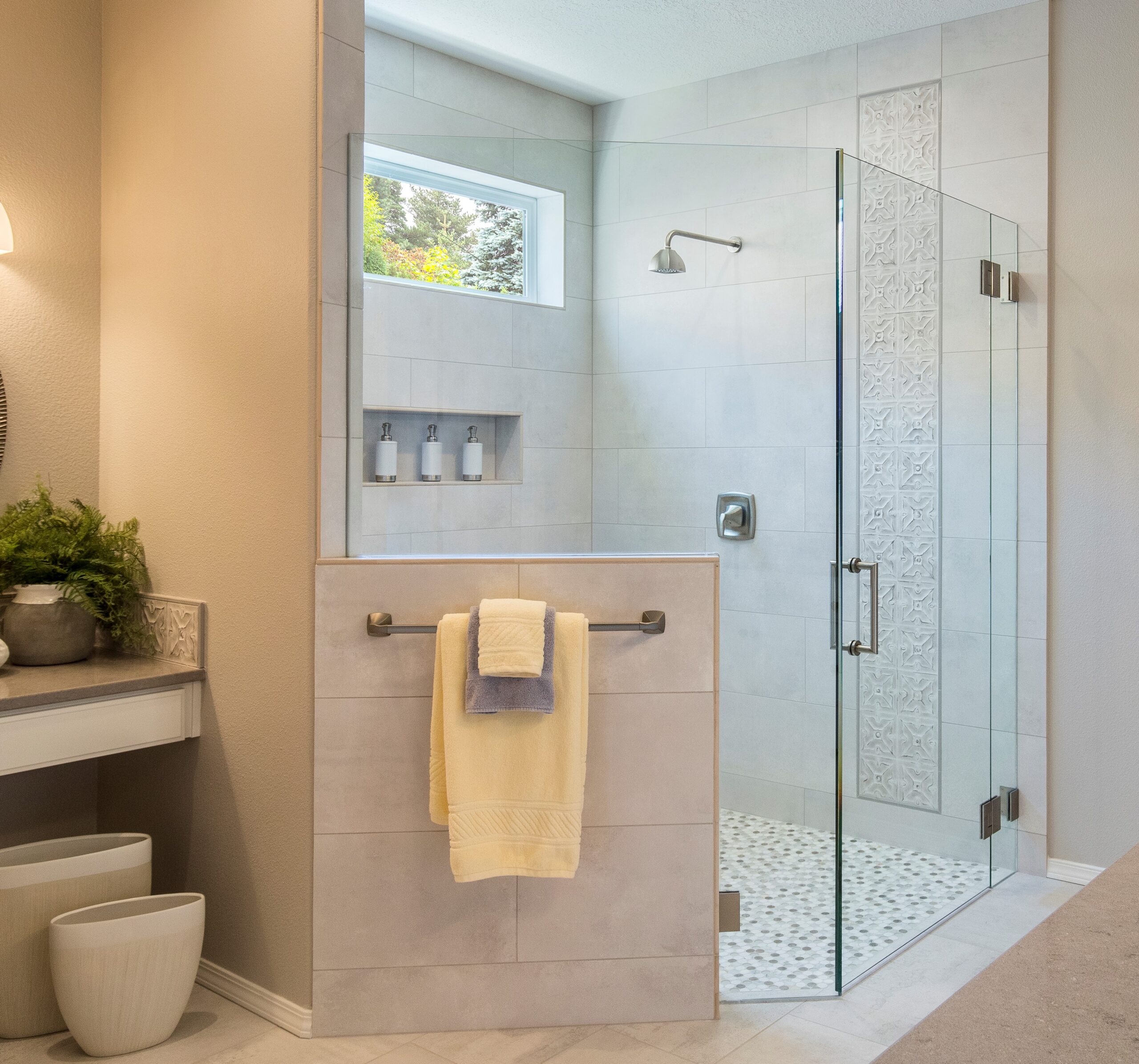 beautiful remodeled bathroom with tile shower, glass doors and counter