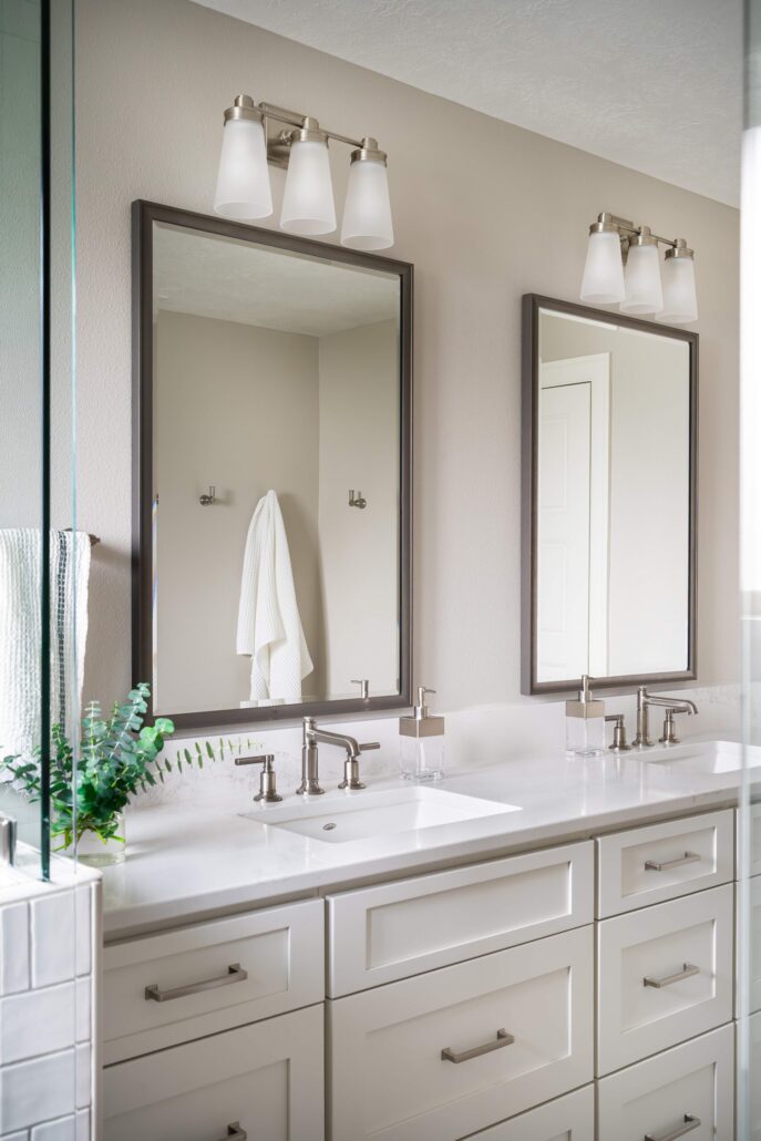 Modern bathroom with dual sinks, large mirrors, chrome fixtures, and white cabinets for a sleek, elegant look.